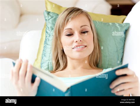 Attractive Woman Reading A Book Lying On A Sofa Stock Photo Alamy