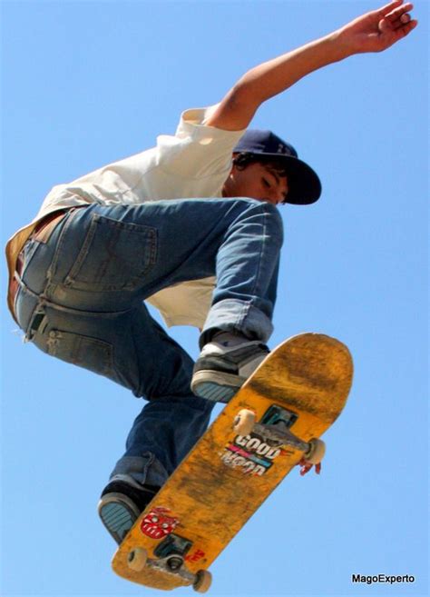 A Man Flying Through The Air While Riding A Skateboard In Front Of A