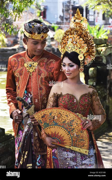 balinese couple in traditional dress take wedding photos inside klungkung palace in semarapura