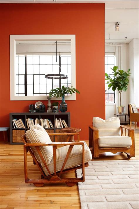 An Orange Living Room With Two Chairs And A Coffee Table In Front Of