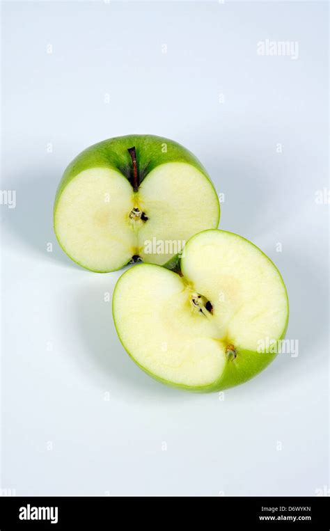 Green Apple Cut In Half Against A Plain Background Stock Photo Alamy