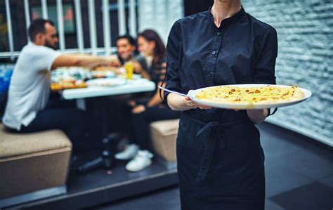 Waiters Carrying Plates With Food In A Restaurant Stock Photo
