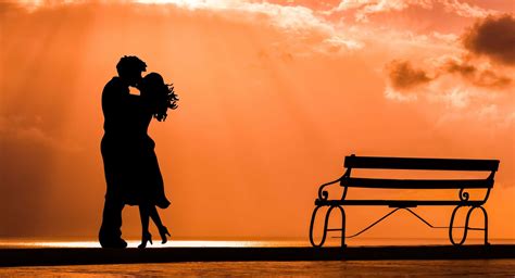 download a romantic couple embracing and enjoying the sunset