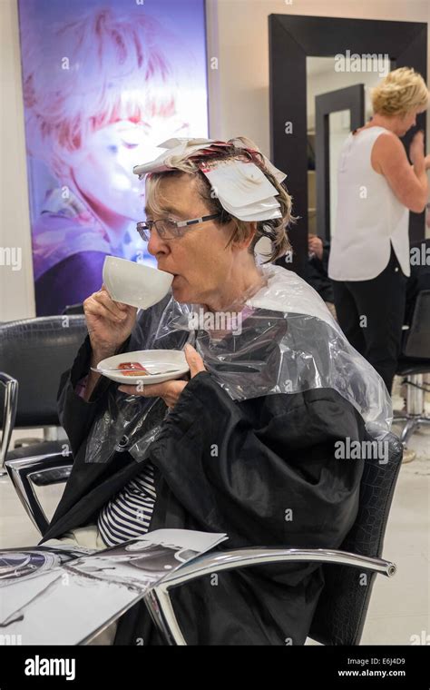 Older Woman In Hair Salon Having Highlights Put In Hair While Drinking