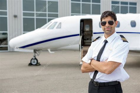 Pilot With Arms Crossed Standing In Front Of Private Jet Stock Photo By