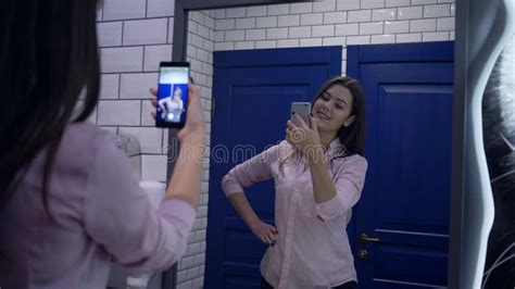 Attractive Girl Posing In Front Of Mirror For Selfie Photo On Cell Phone In Restroom Stock Video