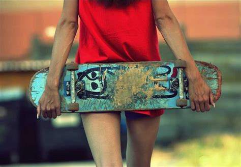 A Woman Holding A Skateboard With Graffiti On Its Sides And Her Legs