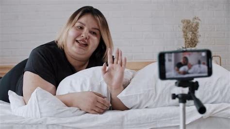 A Confident Overweight Woman Feminist Lying In Bed And Making A Video