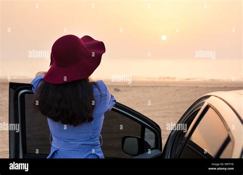 Girl Facing Beach Sunset By The Car Summer Vacation Time Stock Photo