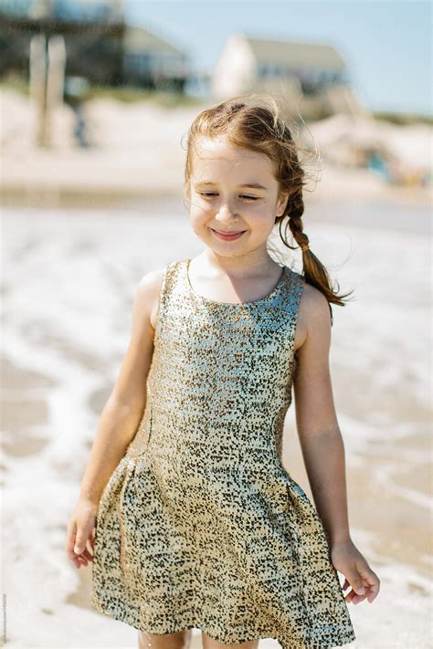 Cute Young Girl Wearing Fancy Gold Dress Playing In The Ocean By Stocksy Contributor Jakob