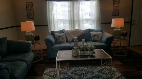 A Living Room With Two Couches And A Coffee Table In Front Of A Window