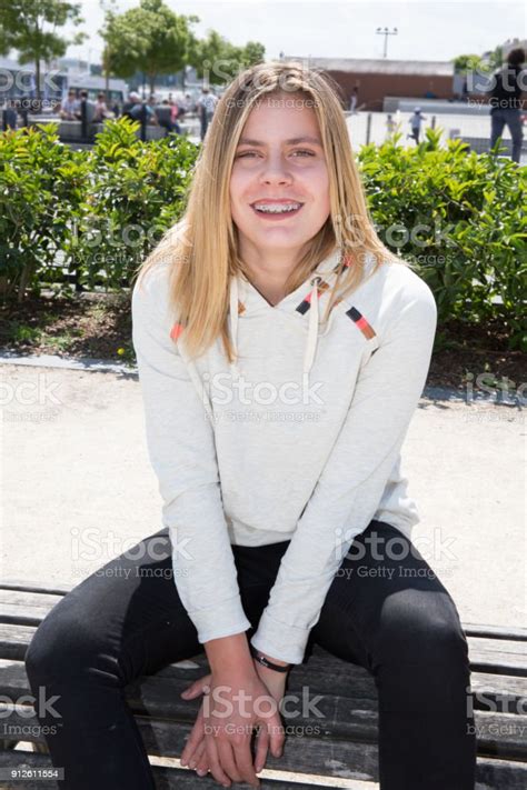 Teenage Blonde Girl Sit On A Bench In City Stock Photo Download Image