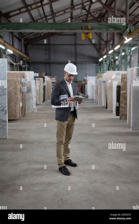 Full Body Male Architect Examining Marble Samples During Work In