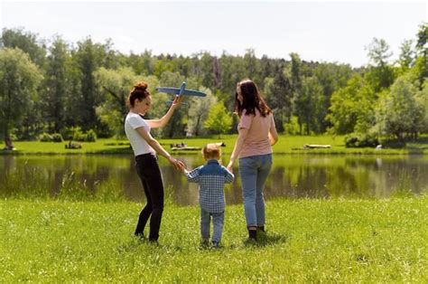 premium photo lesbian couple spending time with their son in the park