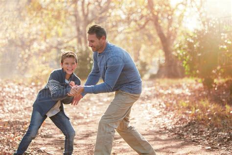 Playful Father And Son On Path In Woods Stock Photo Dissolve