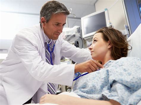 Male Doctor Examining Female Patient In Emergency Room Stock Photo