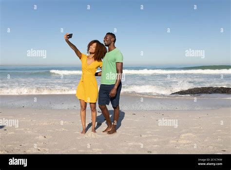 Mixed Race Couple Taking Selfies On The Beach Stock Photo Alamy