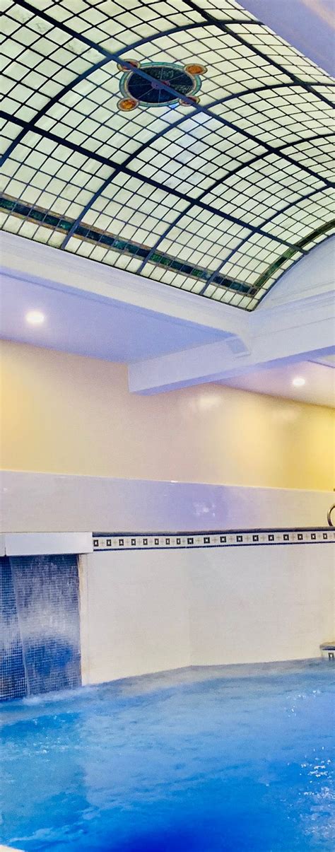 An Indoor Swimming Pool With Blue Water And A Skylight In The Ceiling