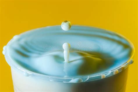 High Speed Photograph Of A Milk Drop On Yellow Background In The Stock