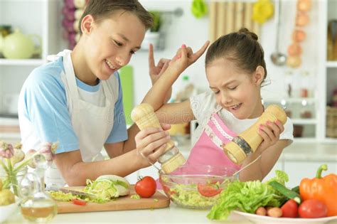 Portrait Of Brother And Sister Cooking Together In Kitchen Stock Image