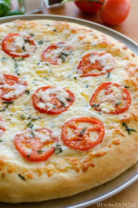 A light pizza with olive oil, garlic, fresh basil, fresh tomatoes, mozzarella and parmesan cheeses. Margherita Pizza