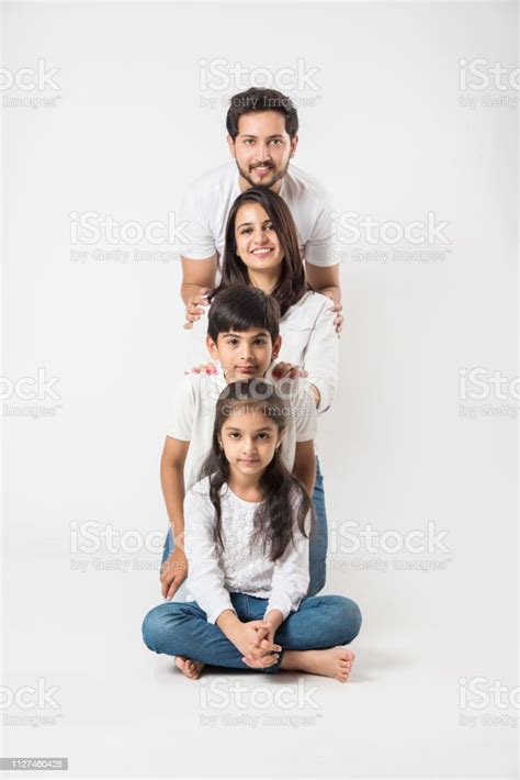 glückliche indische familie von 4 stehenden isoliert auf weißem hintergrund junges paar mit
