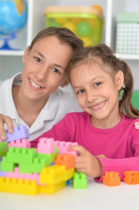 brother and sister playing with colorful plastic blocks together stock image image of people