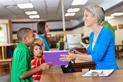 Royalty Free Friendly Librarian Helping Student Check Out Library Books