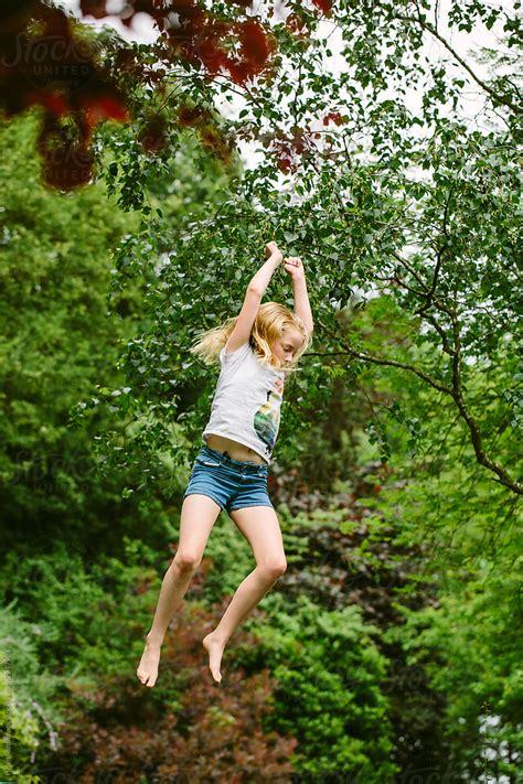 Tween Girl Jumping High In The Air Among Trees By Stocksy Contributor