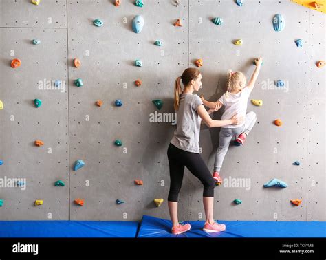 Instructor Helping Little Girl To Climb Wall In Gym Stock Photo Alamy