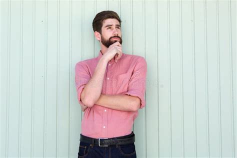 Pensive Young Man Standing Alone With Hand To Chin Stock Photo Image