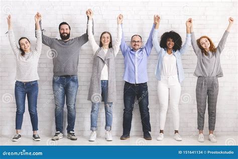 Group Of Successful Friendly People Raising Connected Hands Stock Photo