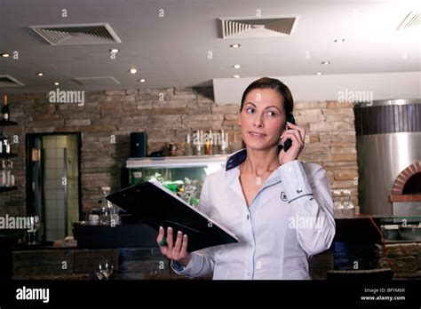 Restaurant Owner Taking Reservation On Mobile Phone Stock Photo Alamy