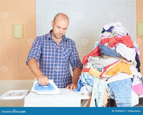 Caucasian Man Ironed Clothes In The Room Near The Window Stock Image