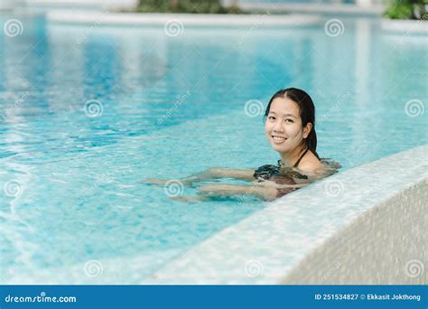 A Cute Teenage Asian Female Tourist Is Happily Swimming In The Pool On A Day Of Sightseeing And