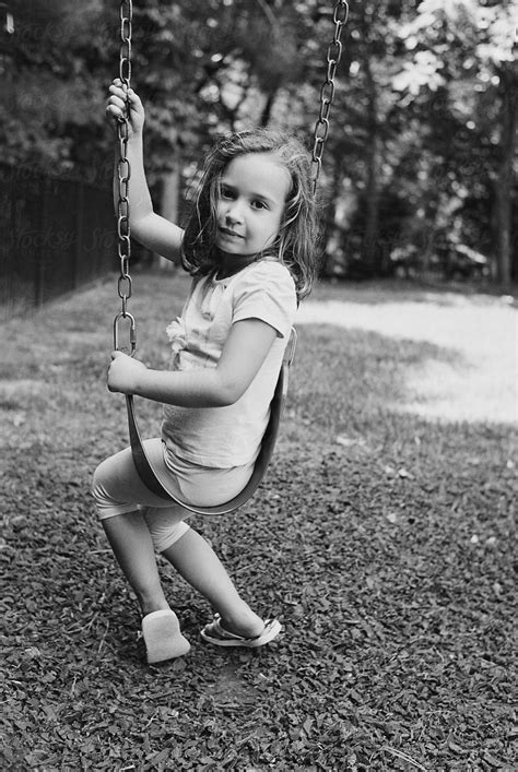 Black And White Portrait Of A Young Girl Sitting On A Swing By Stocksy Contributor Jakob