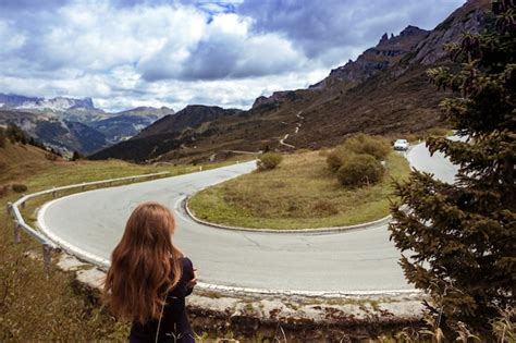 Premium Photo Passo Pordoi Girl Looks At The Turn Of The Road In The