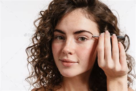 Half Naked Curly Woman Plucking Her Eyebrows And Looking At Camera Stock Photo By Vadymvdrobot