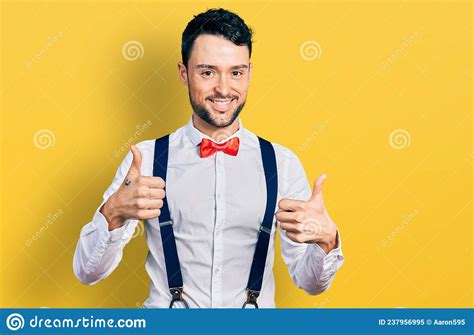Hispanic Man With Beard Wearing Hipster Look With Bow Tie And Suspenders Success Sign Doing