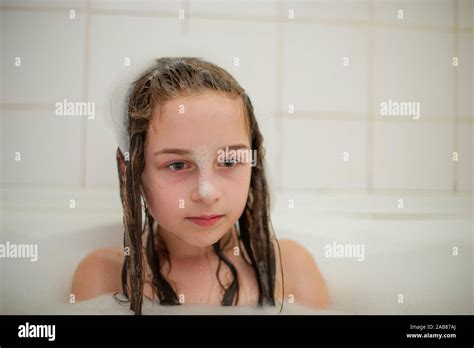 Young Girl Inside The Bath A Little Girl Bathes In A Bathtub With Foam