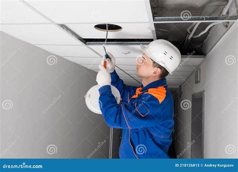 An Electrician Installing Lighting In A False Ceiling Side View Stock