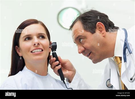 Doctor Using An Otoscope To Look At The Ear Of His Patient Stock Photo