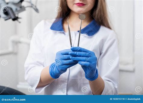 Portrait Of Young Beautiful Female Dentist Holding Dental Tools At The