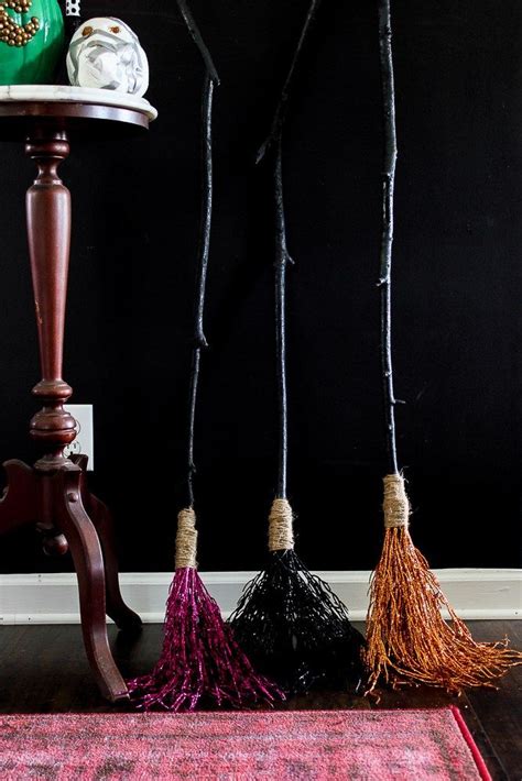 Three Tasseled Brooms Are Hanging From A Table