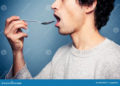 Young Man Eating From A Spoon Royalty Free Stock Photo Image 36025035