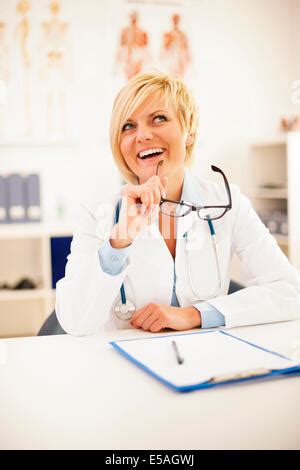 Hermosas mujeres médicos con estetoscopio y portapapeles sonriendo a cámara aislado en blanco