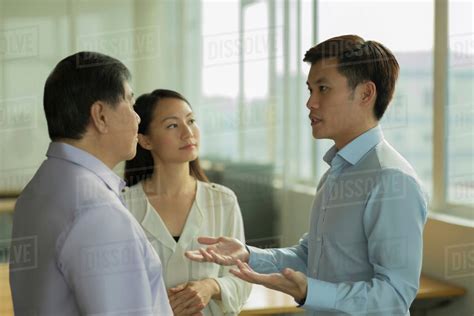 Three People Talking In Office Stock Photo Dissolve