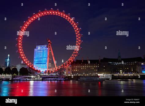 London Eye Ferris Wheel Illuminated In Red In The Night Reflection