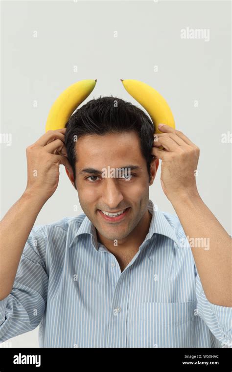 Man Holding Two Bananas On Head And Smiling Stock Photo Alamy