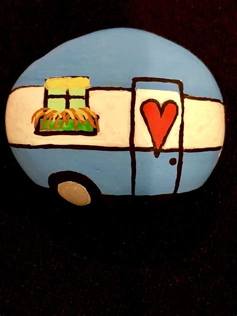 A Painted Rock With A Camper And Heart On Its Side Sitting On A Black